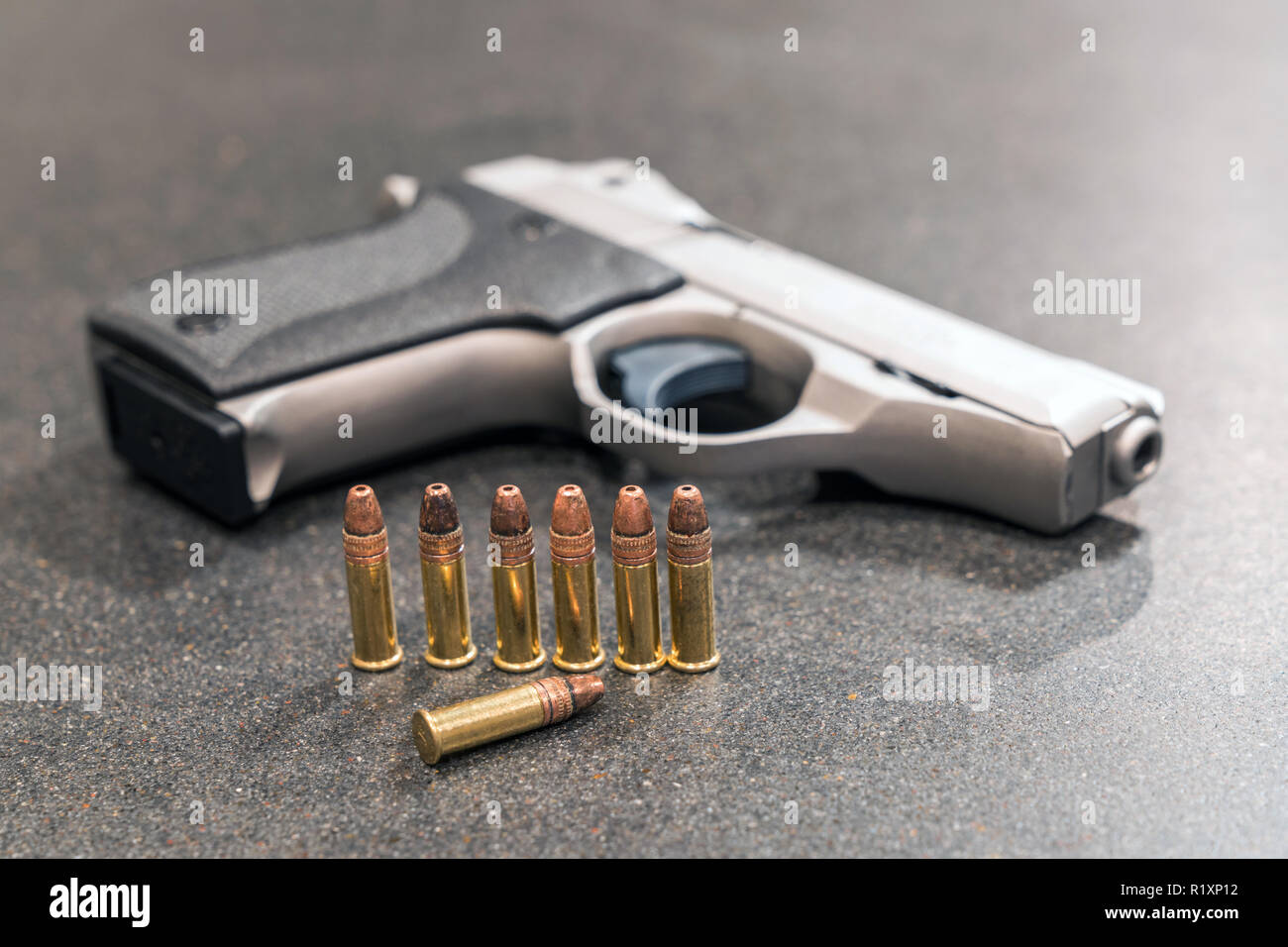 I proiettili e pistola sulla tavola nera Foto Stock