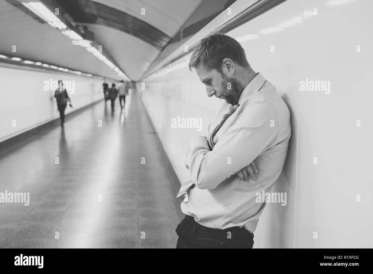 Desperate triste giovane impreditore sofferenza dolore emotivo dolore e profonda depressione seduto da solo nel tunnel della metropolitana Stress in stile di vita problemi di lavoro f Foto Stock