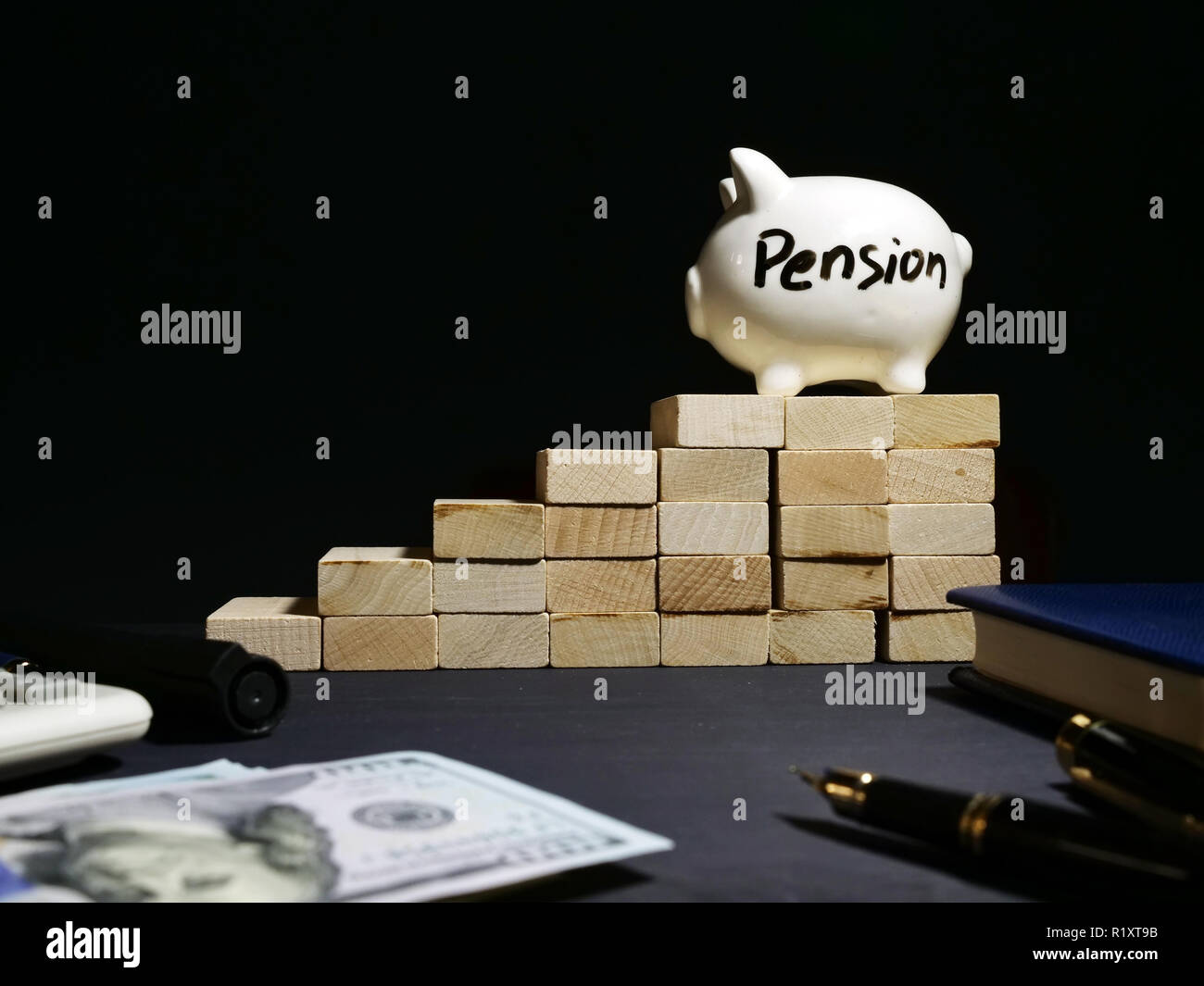 Pension scritto su un salvadanaio su una scala in legno. Risparmi per il pensionamento. Foto Stock