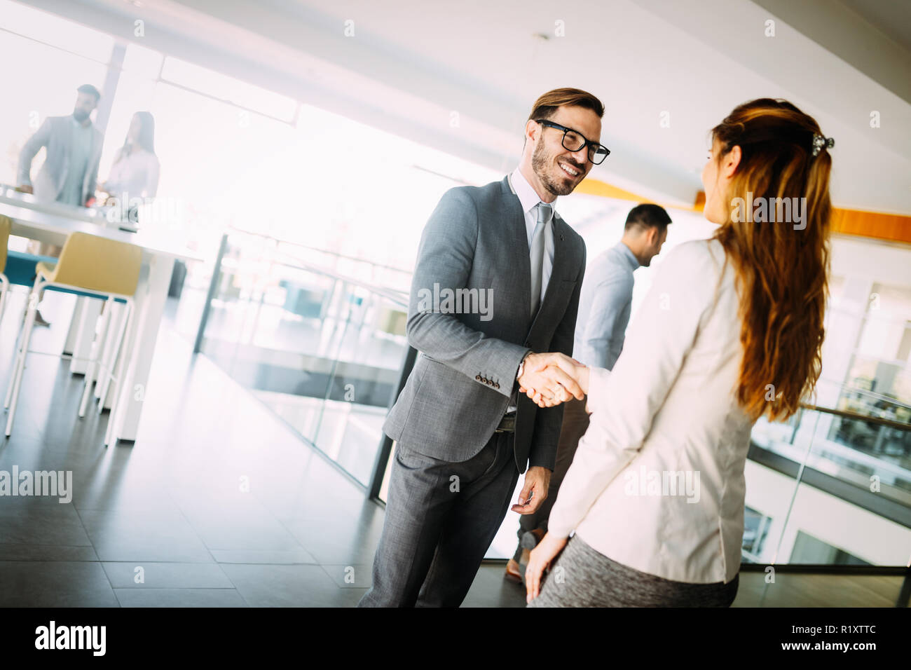 Giovane imprenditore e la donna agitare le mani come hello in office ritratto Foto Stock