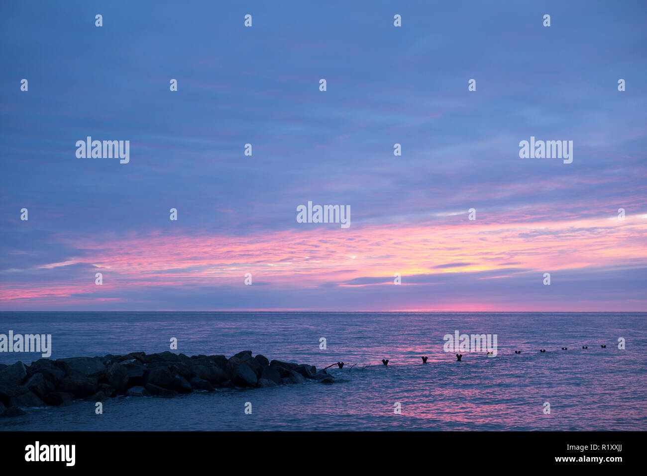 Mozzafiato, spettacolari colori pastello del tramonto sopra l'Oceano Atlantico in Galles Foto Stock