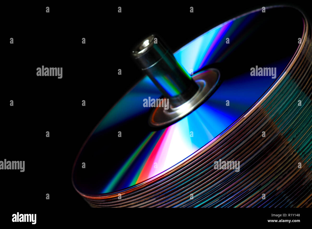 Pila di CD su uno sfondo scuro con colorate bande rifrangenti Foto Stock