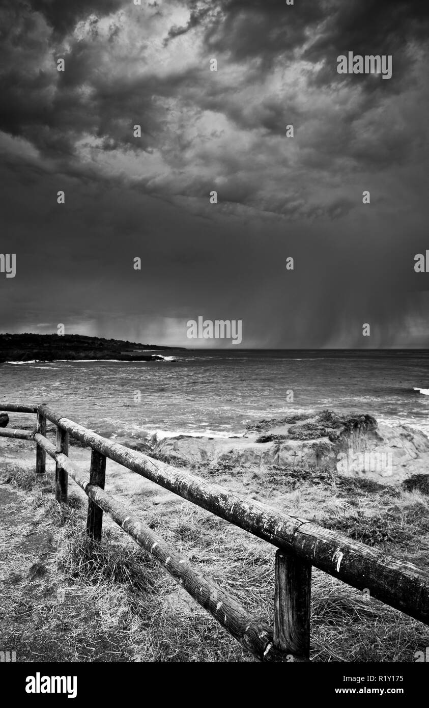 Tempesta tempo in monocromia, venendo in dal Pacifico oceano legno posta di sicurezza in primo piano, Coastal, California, Stati Uniti, Foto Stock