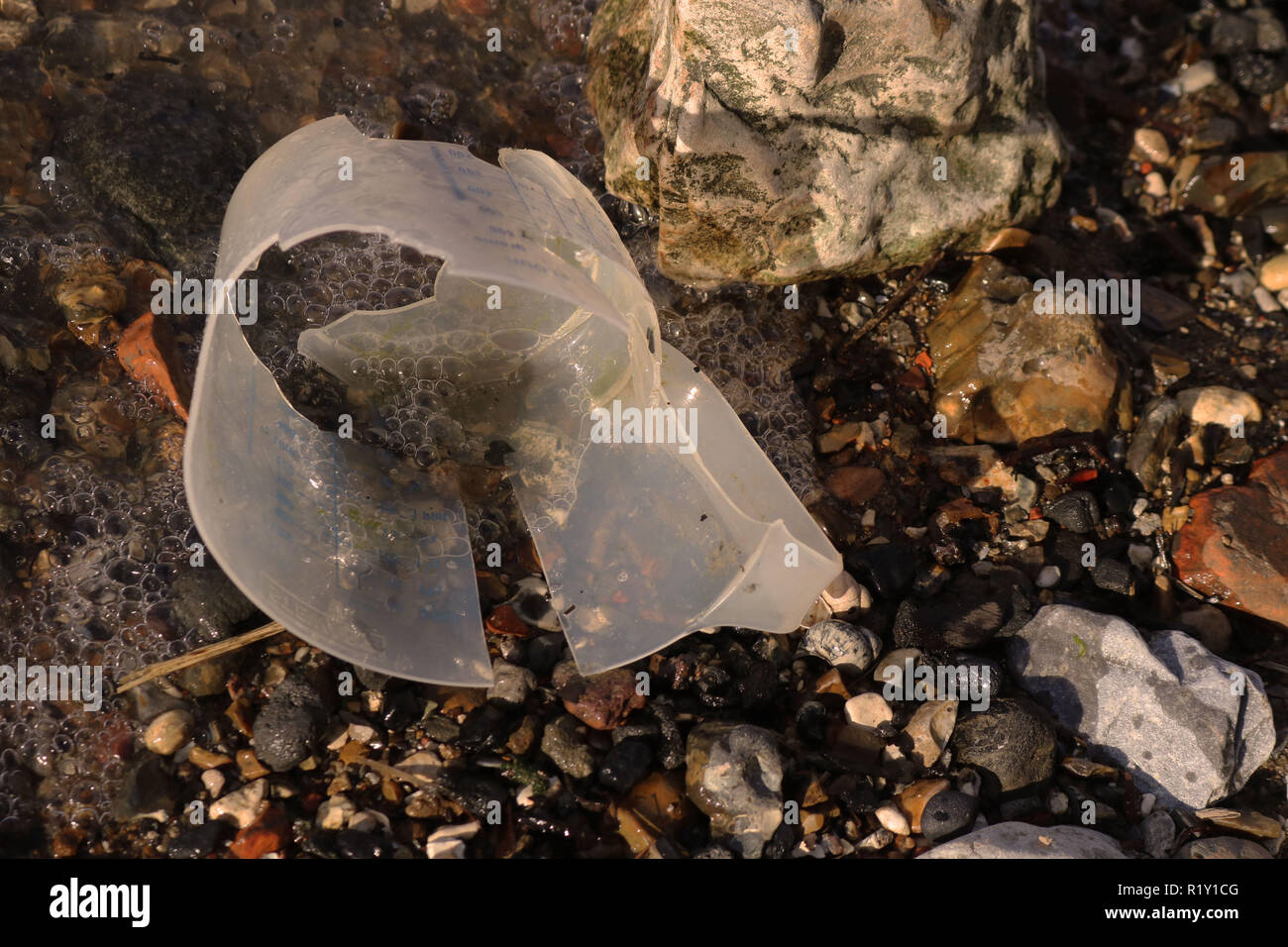 Plastica misurino trovato nel fiume Tamigi per mostrare l'uso elevato di plastica utilizzata nell'ambiente. Foto Stock