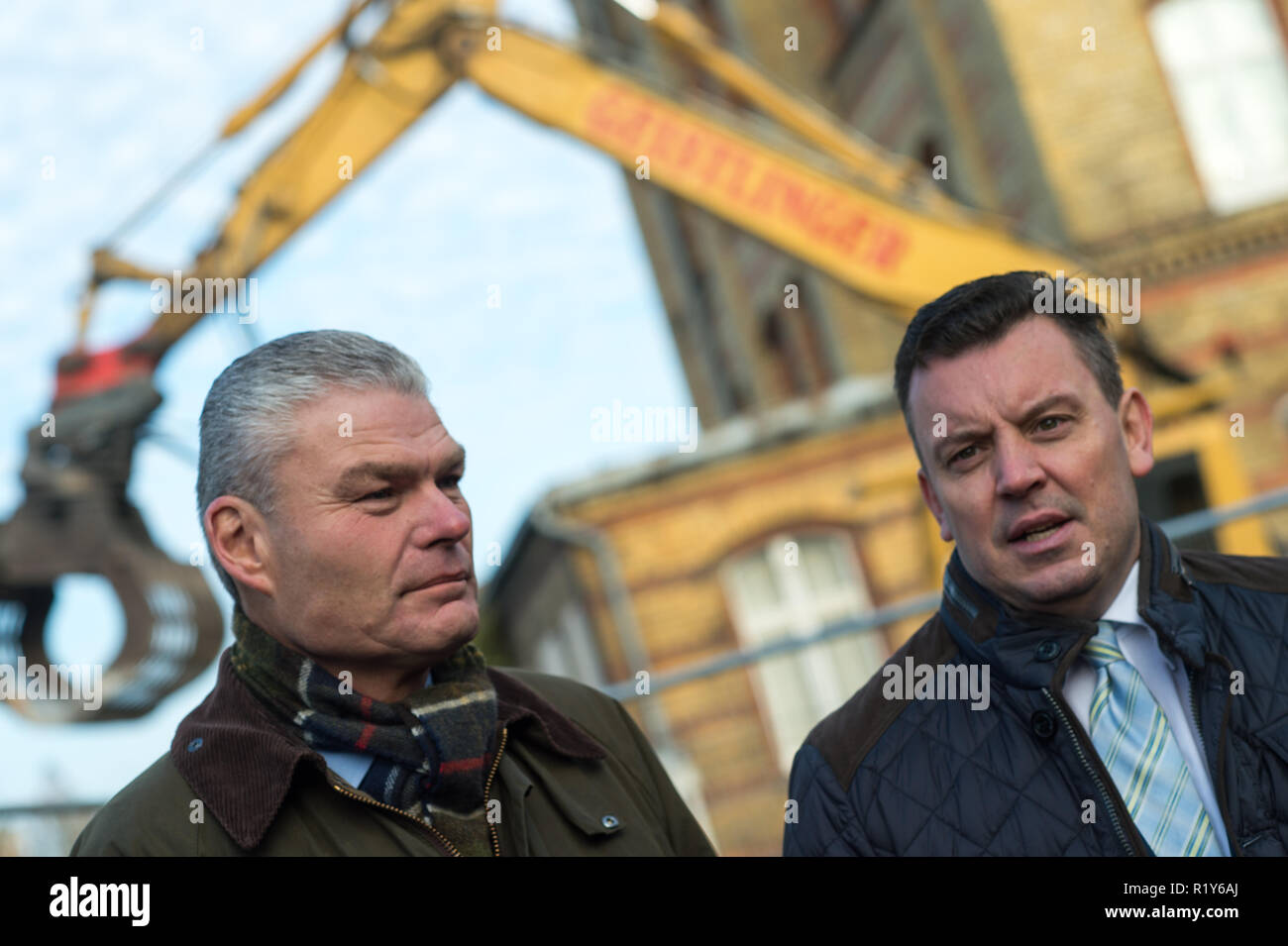 Magdeburg, Germania. Xv Nov, 2018. Holger Stahlknecht (l, CDU), il ministro degli Interni del Land Sassonia-Anhalt, e Andre Schröder (CDU), il ministro delle Finanze del Land Sassonia-Anhalt, stare di fronte ad una costruzione recinzione e guarda le misure di costruzione presso il Quartier Generale della Polizia a nord. La demolizione di una sala sportiva aveva cominciato. Il Quartier Generale della Polizia Sassonia-anhalt Nord è stato votato il peggior servizio edificio in Germania ed è ora in fase di ristrutturazione. Credito: Klaus-Dietmar Gabbert/dpa-Zentralbild/dpa/Alamy Live News Foto Stock