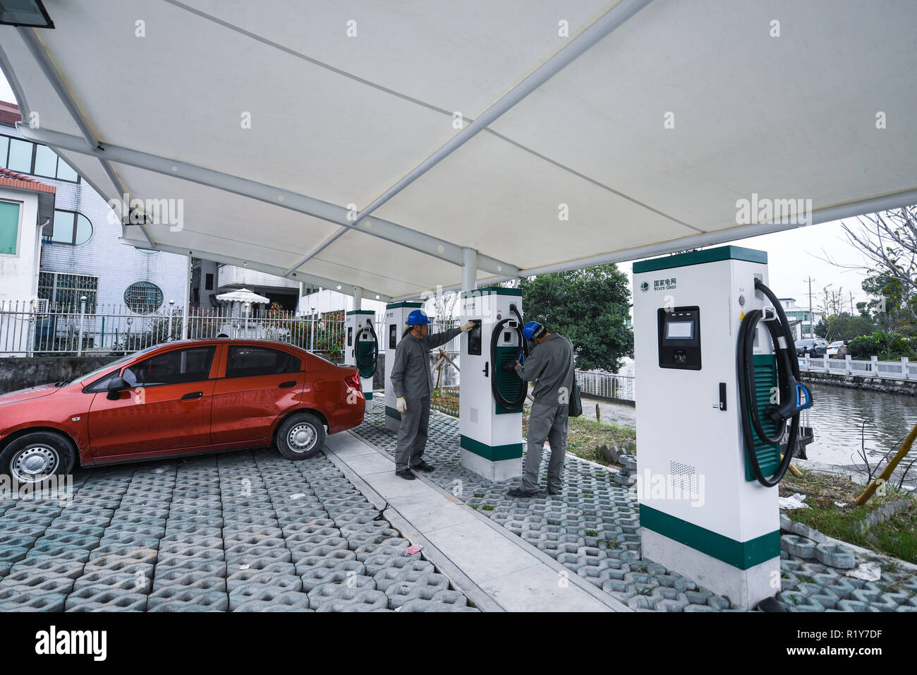 Wenzhou, cinese della Provincia di Zhejiang. Xv Nov, 2018. Il personale controllare le pile di carica elettrica per automobili a Zhangli Village di Wenzhou, est della Cina di Provincia dello Zhejiang, su nov. 15, 2018. Dal 2017, Zhangli village ha preso varie misure volte a promuovere a basso tenore di carbonio, di stile di vita mediante l'installazione di pannelli solari fotovoltaici sui residenti' casa tetti, impostazione di pile di carica elettrica per automobili, che istituisce le acque piovane i sistemi di riciclaggio e così via, per creare un più rispettosi dell'ambiente living place. Credito: Xu Yu/Xinhua/Alamy Live News Foto Stock