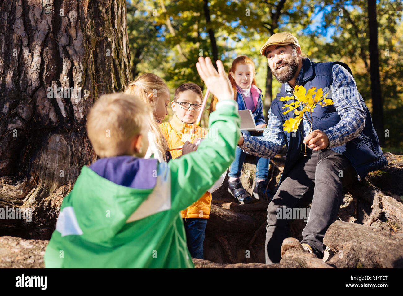 Gioioso insegnante positivo parlare ai suoi allievi Foto Stock