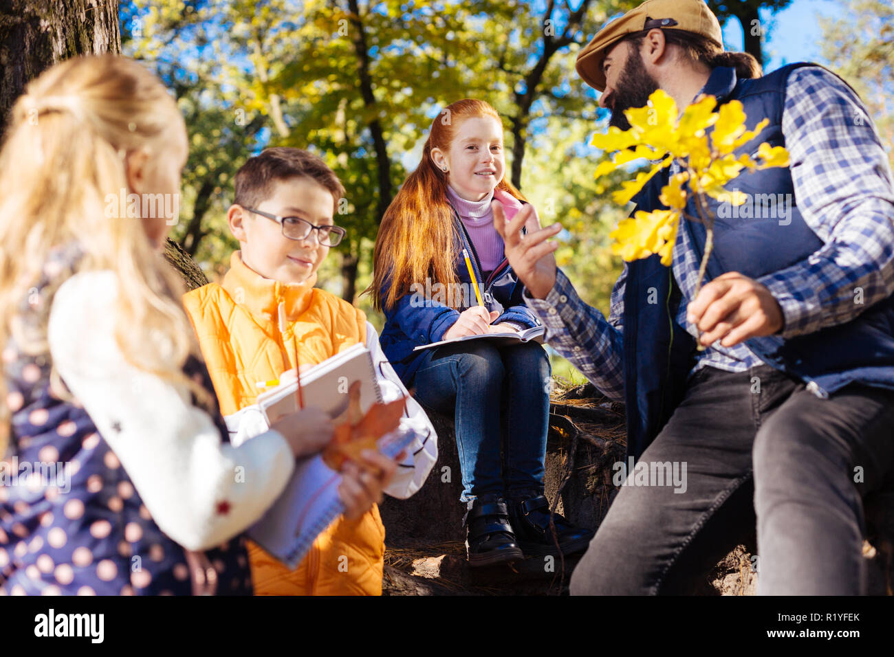 Felice curioso bambini ascolto al loro insegnante Foto Stock