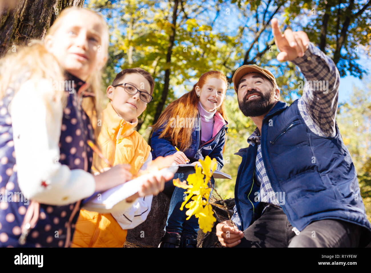 Gioiosa smart uomo barbuto che mostra la foresta di autunno Foto Stock