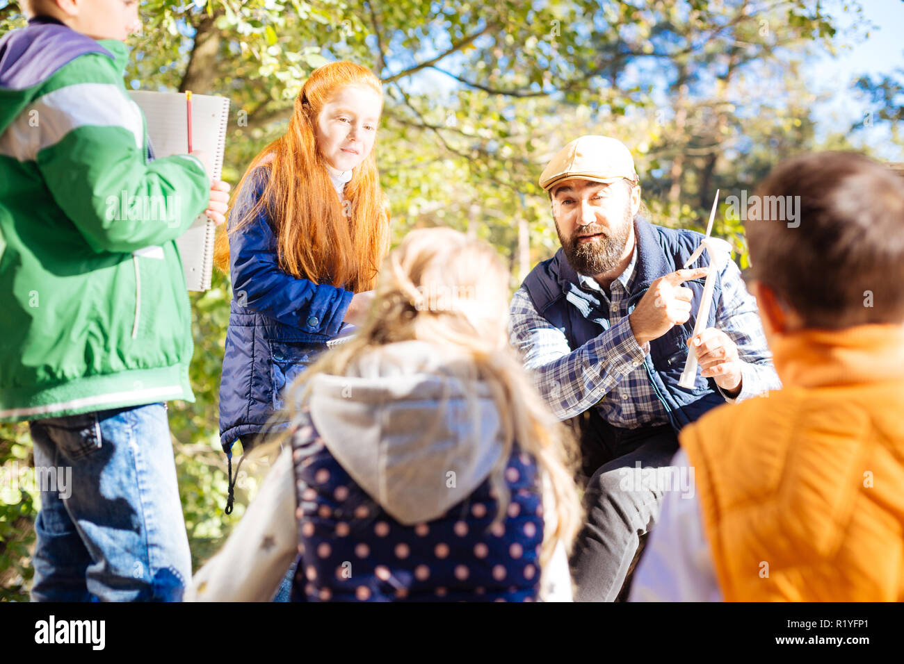 Piacevole insegnante maschio puntando verso il modello di mulino a vento Foto Stock