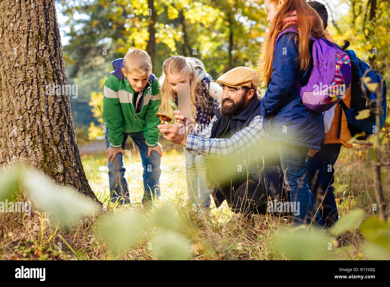 Positivo l'uomo felice di scattare le foto sul suo smartphone Foto Stock