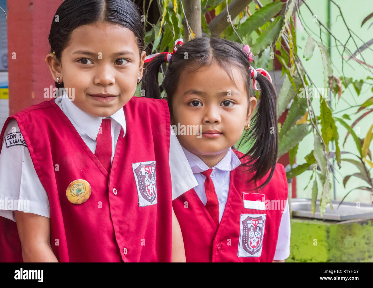 Studentesse indonesiano in uniforme in posa davanti la loro scuola Foto Stock