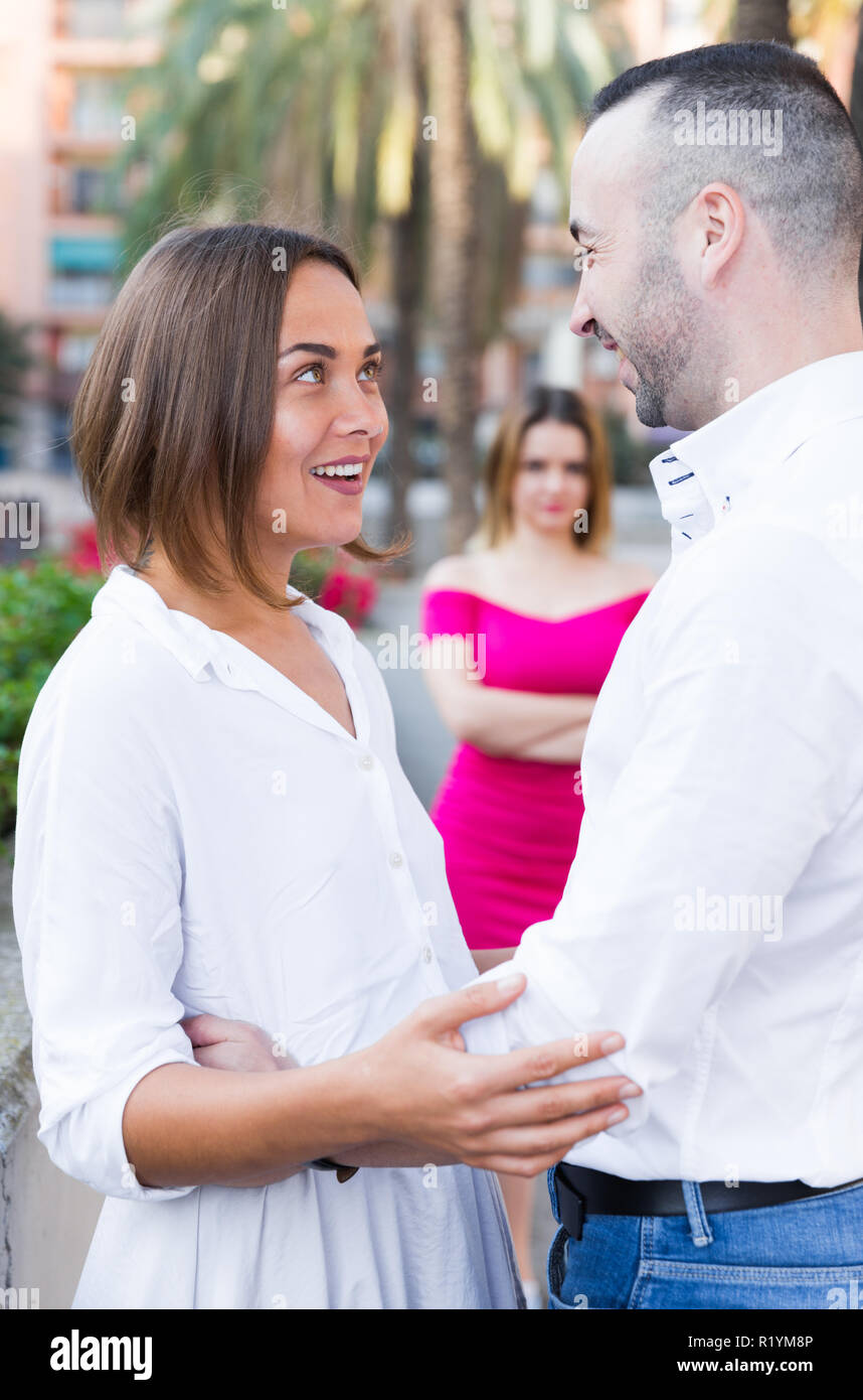 Giovane donna è flirtare con il mio ragazzo quando la sua fidanzata è li invidie all'esterno. Foto Stock