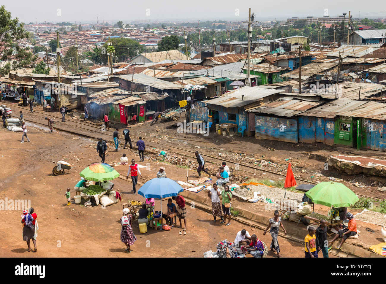 Vista di una sezione di Kibera slum che mostra baracca di fortuna alloggiamento e residenti andando sulla vita quotidiana, Nairobi, Kenia Foto Stock