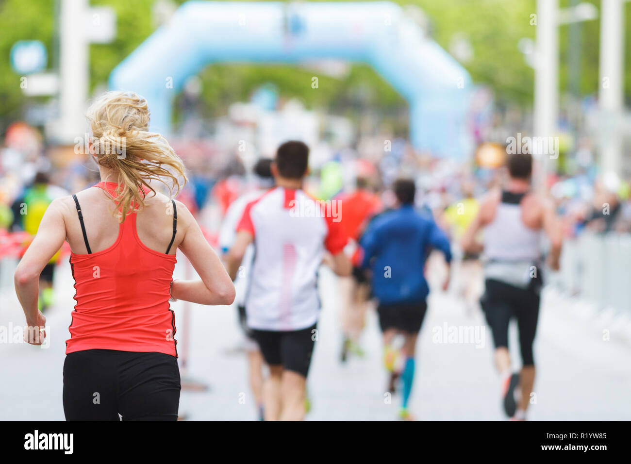 Esecuzione di donna e di fronte alla folla alla maratona di inizio o di fine linea Foto Stock