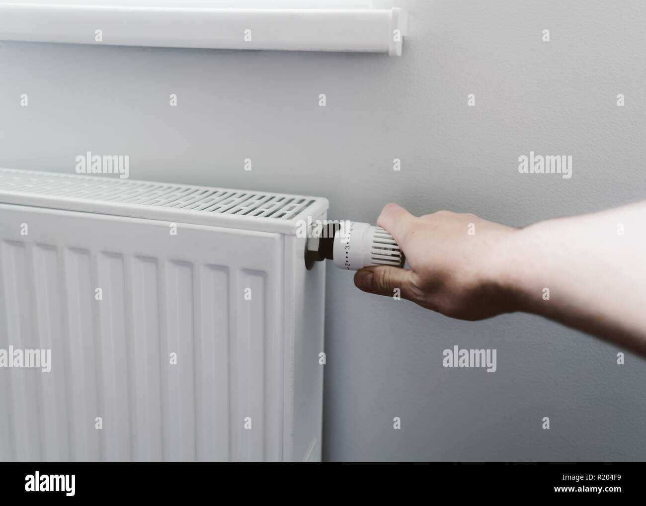 Gli uomini a mano la temperatura della batteria del controller closeup riscaldamento Foto Stock