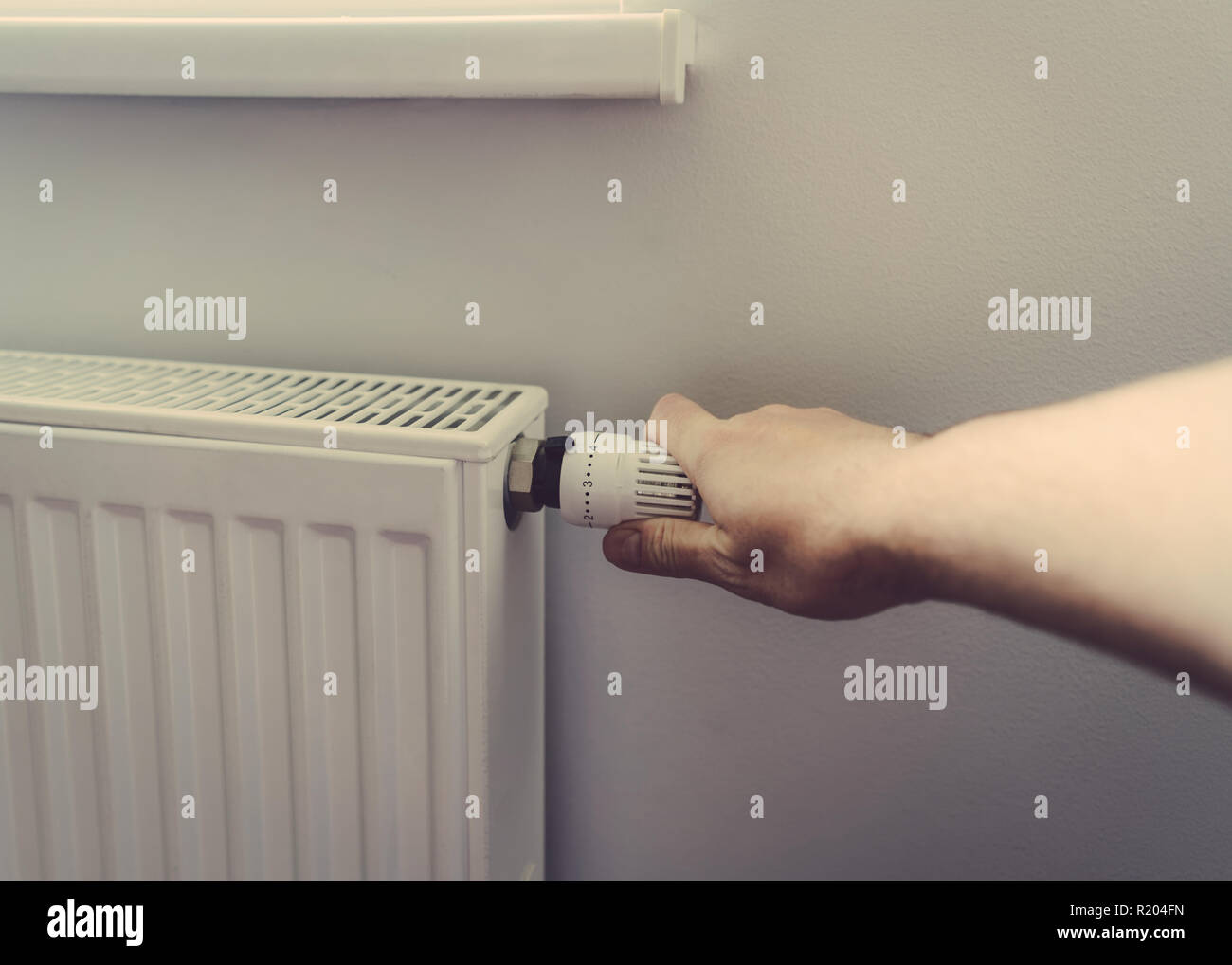 Gli uomini a mano la batteria del controller di temperatura riscaldamento close up Foto Stock
