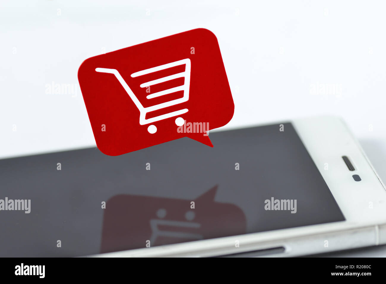 Smartphone e bolle di messaggio con un carrello di shopping - Online shopping concept Foto Stock