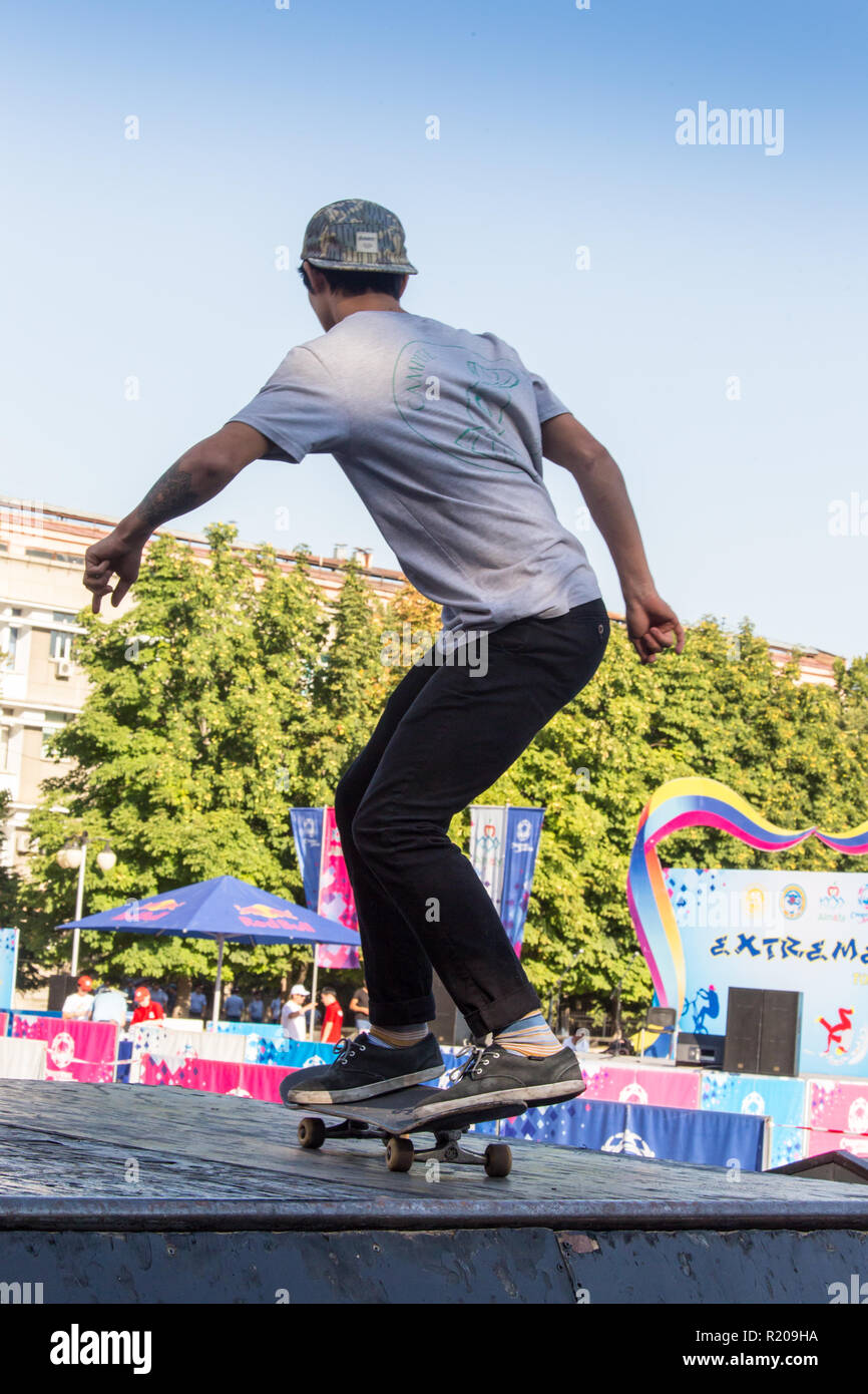 Il Kazakistan ALMATY - Agosto 28, 2016: Urban estrema concorrenza, dove la città gli atleti competere nelle discipline: skateboard, pattini a rotelle, BMX. Guidatore di skateboard facendo un trick in skate park Foto Stock