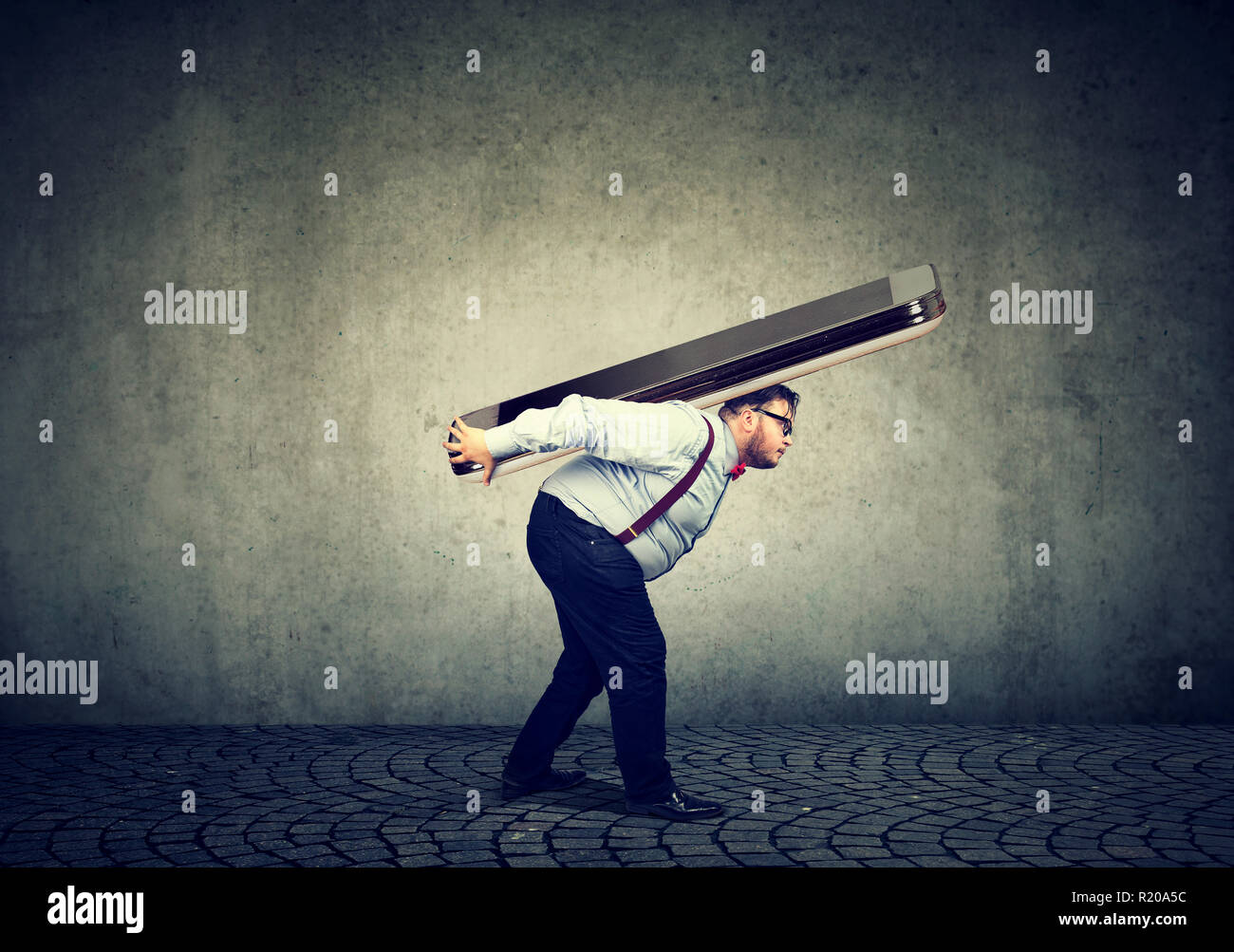 Paffuto uomo d affari che lottano per portare lo smartphone enorme Foto Stock