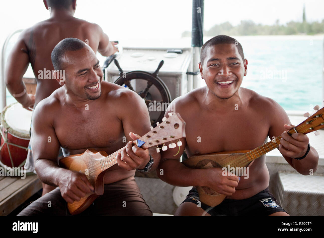 Guide ukuleles giocando a bordo di una barca con fondo di vetro per tour in muri Lagoon, Rarotonga Isole Cook. Foto Stock