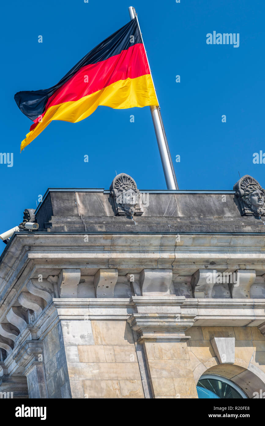 Il tedesco della bandiera nazionale vola sopra il Reichstag di Berlino, Germania. Foto Stock