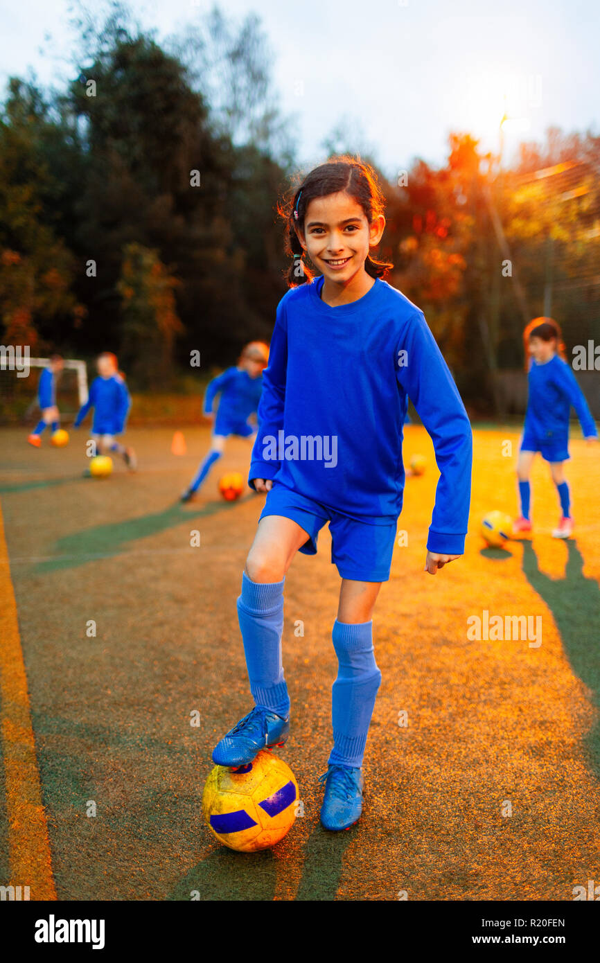 Ritratto fiducioso ragazza pratica soccer sul campo Foto Stock