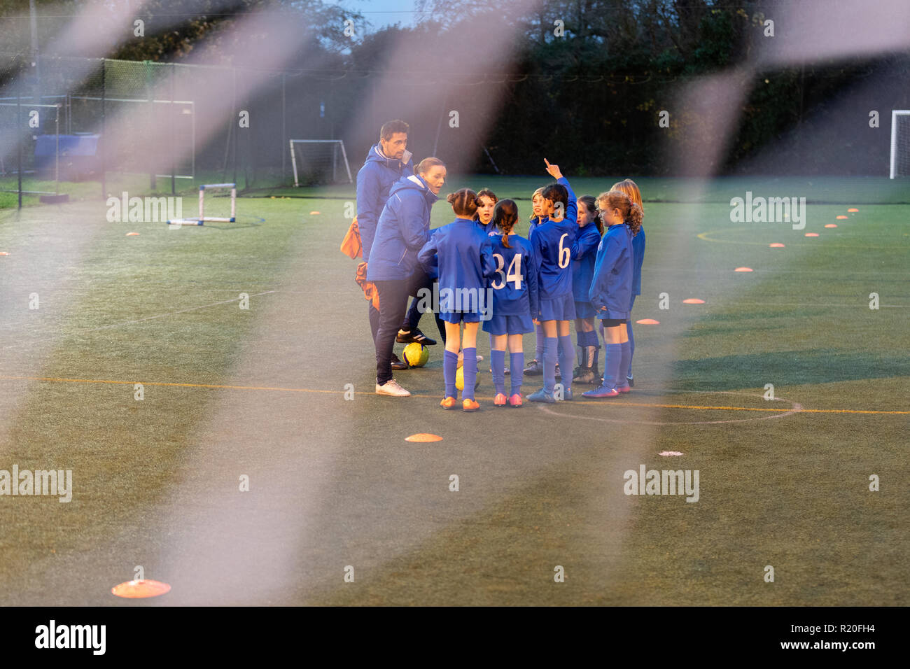 Allenatori di calcio e una ragazza Calcio team parlando sul campo Foto Stock