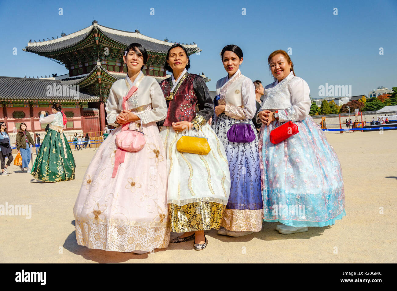 Gruppo di amici posano per una foto al Palazzo Gyeongbokgung in Seoul, vestito in coreano tradizionale abito, il hanbok. Foto Stock