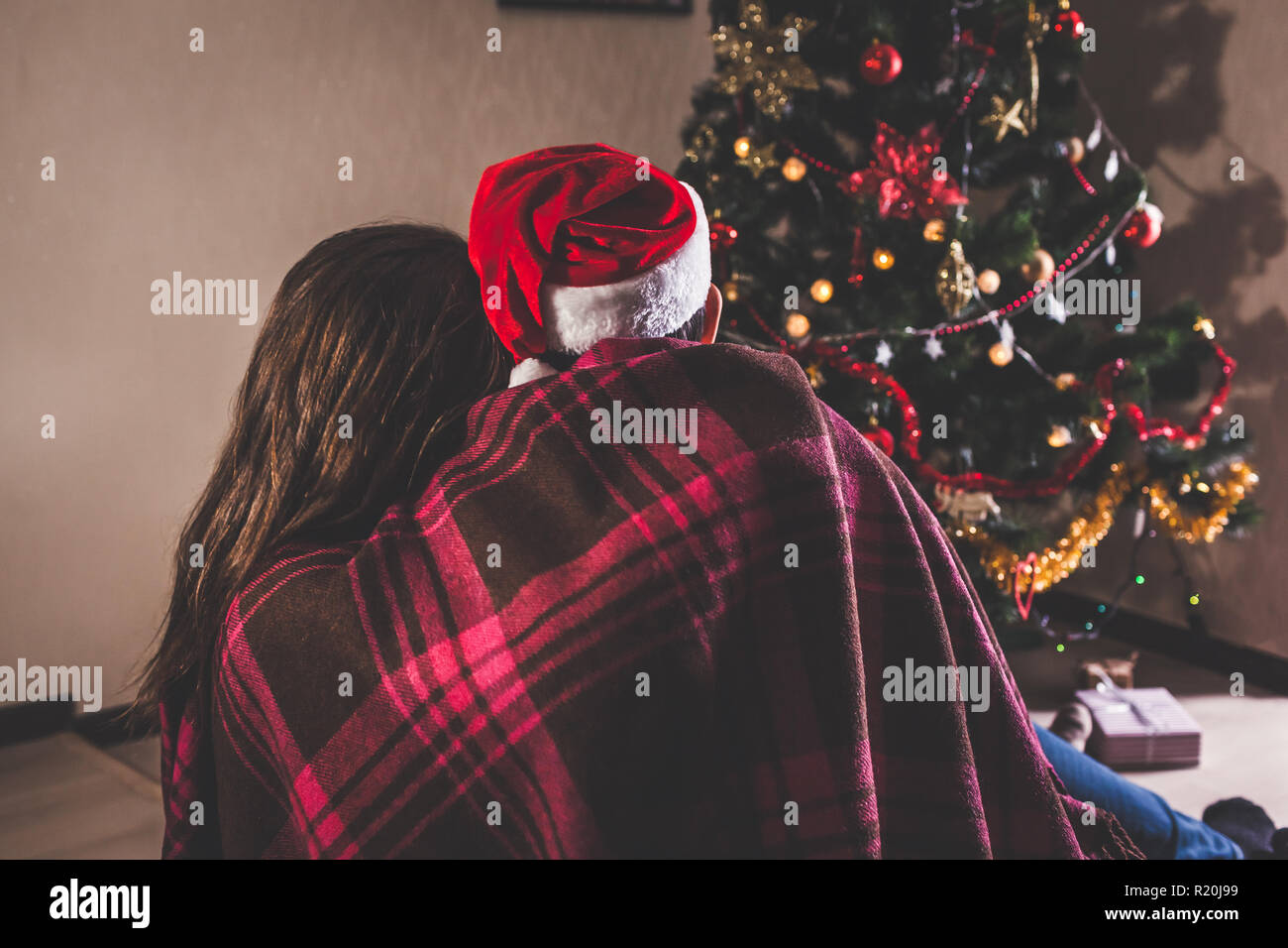 Immagini Natale Amore.Matura In Amore Seduto Accanto A Un Albero Di Natale Indossando Santa S Hat E Avvolgente I Giovani Per Celebrare Il Nuovo Anno A Casa Di Notte Foto Stock Alamy