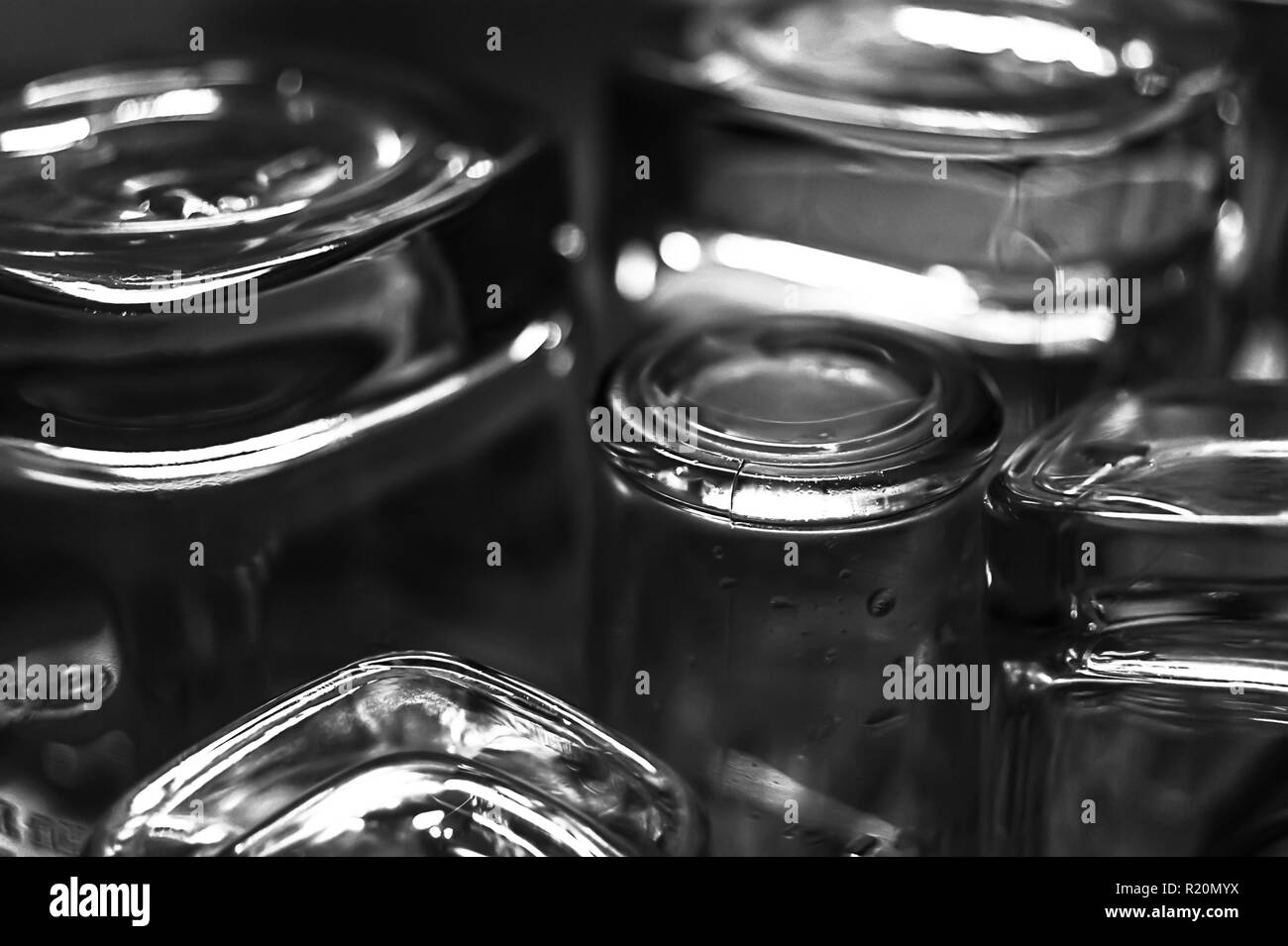 In bianco e nero di close-up immagine di whiskey in vecchio stile o rocce bicchieri lungo con shot o tiratore occhiali su un piatto sgocciolatoio in cucina Foto Stock