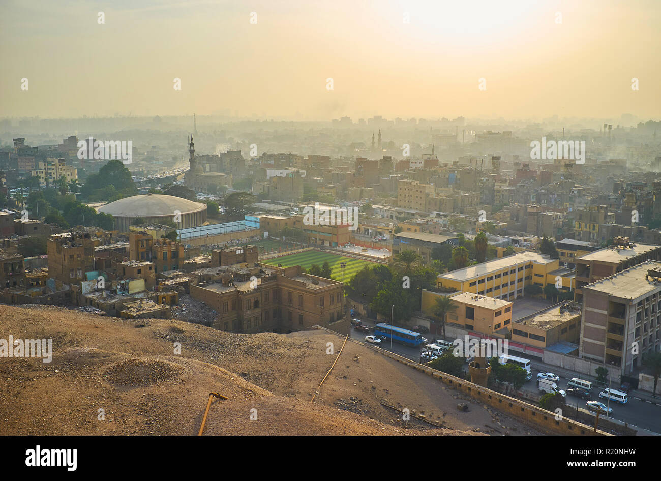 Guardare il tramonto sopra i foggy quartieri residenziali del Cairo dalla parete della cittadella di Saladino, Egitto. Foto Stock