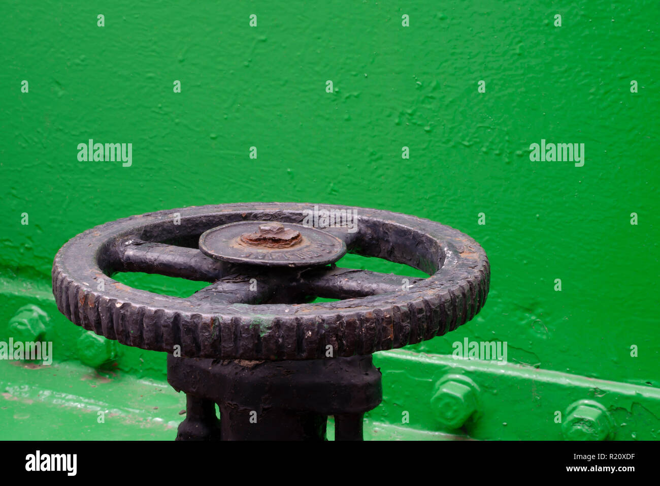 Un ben indossato e parzialmente corroso nave valvola del spicca in rilievo stark contro un luminoso dipinte di verde dello sfondo. Foto Stock