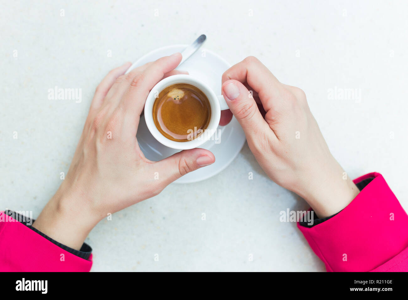 Donna detiene una tazza di caffè espresso, vista dall'alto Foto Stock