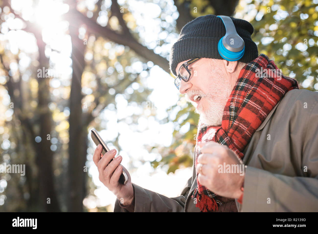 Senior piacevole uomo che ascolta la sua canzone preferita Foto Stock