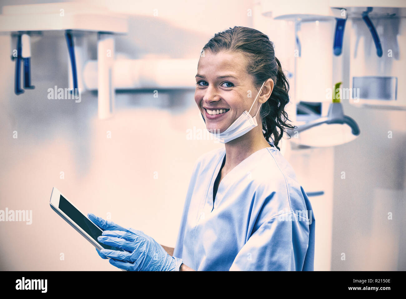 Sorridente assistente dentale usando tavoletta digitale Foto Stock