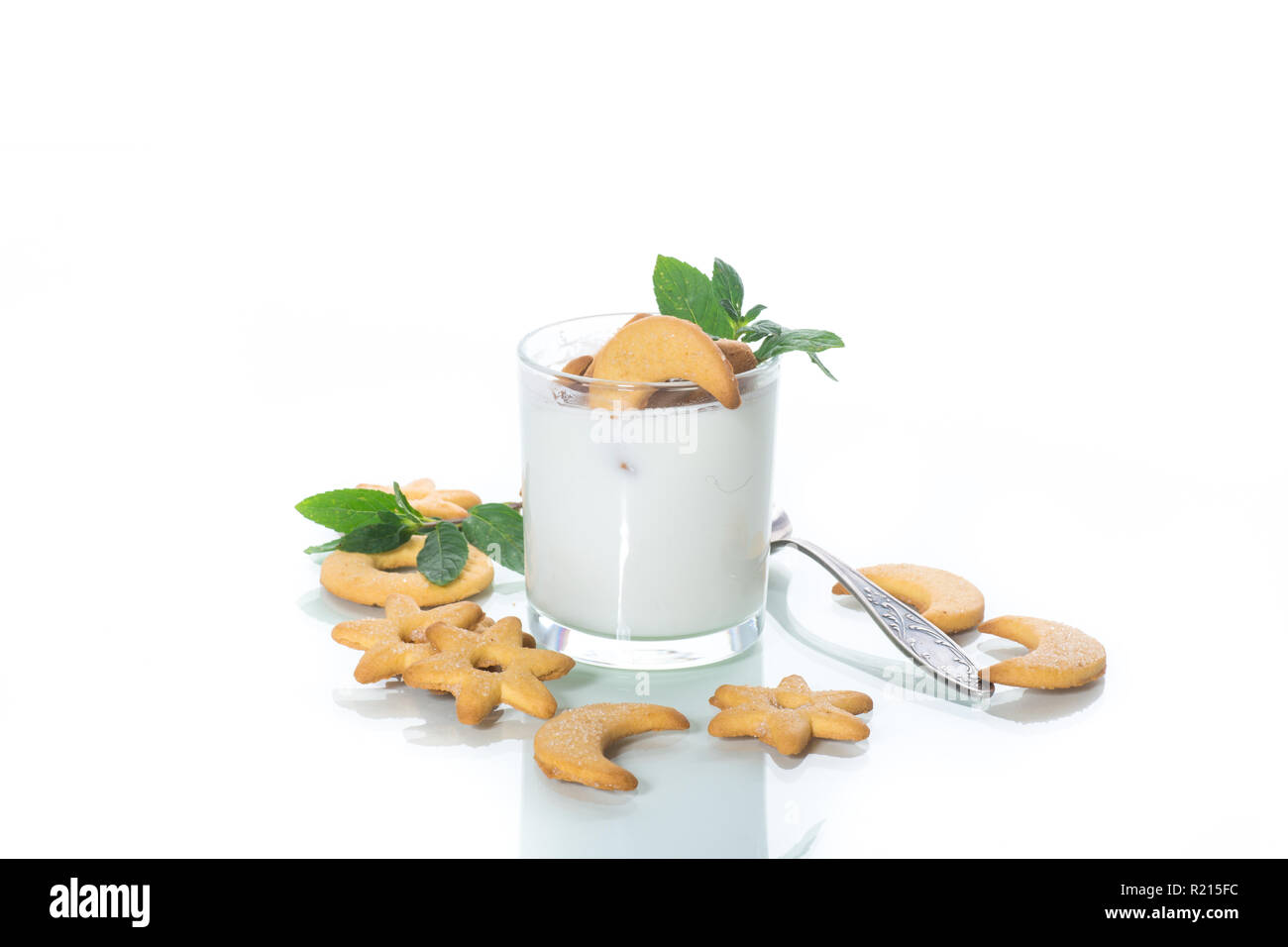 Dolce yogurt fatto in casa con i cookie in un bicchiere di vetro su uno sfondo bianco Foto Stock