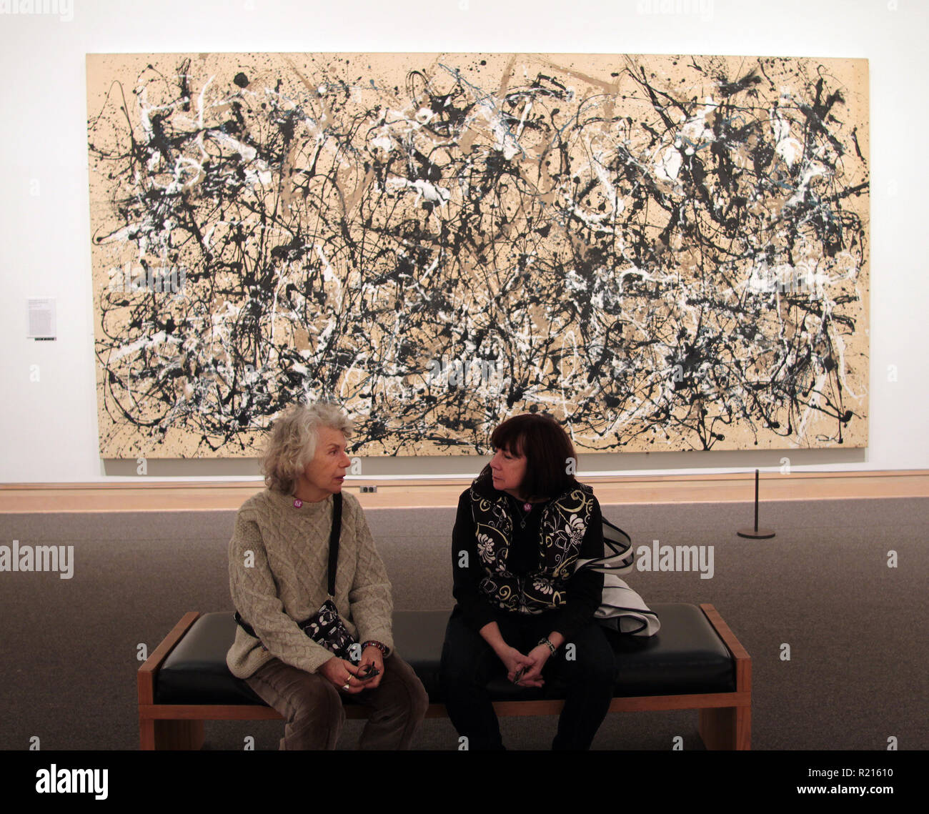 Due donne stanno avendo una chat con lo sfondo di un Jackson Pollock nel Metropolitan Museum of Art di New York. Foto Stock