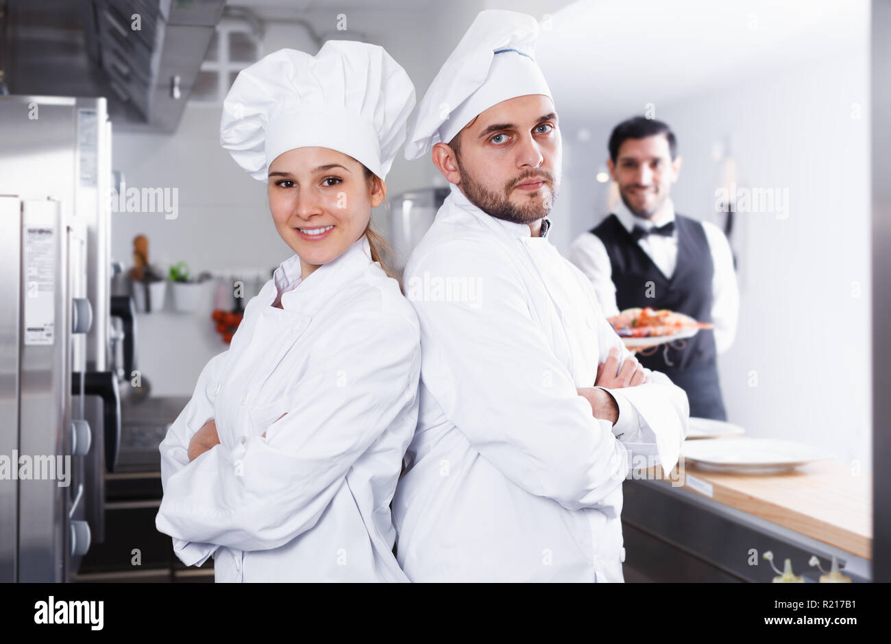 Ritratto di cuochi professionisti in cucina su sfondo del ristorante  cameriere con piatto di frutti di mare Foto stock - Alamy