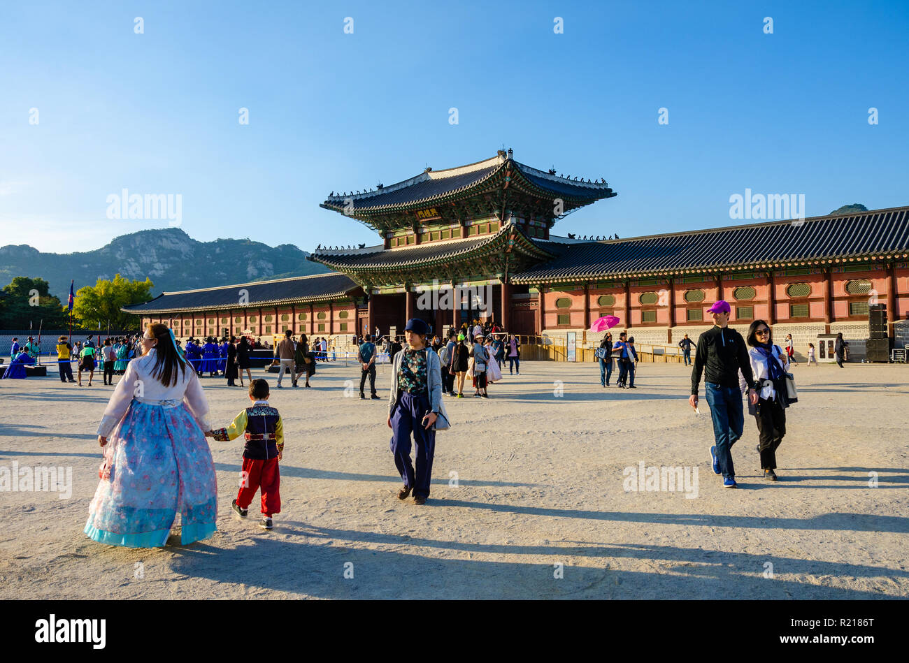 Vista attraverso un affollato cortile pieno di turisti e visitatori in corrispondenza di un cancello ornati presso il Palazzo Gyeongbokgung a Seul, Corea del Sud Foto Stock Vista attraverso un affollato cortile pieno di turisti e visitatori in corrispondenza di un cancello ornati presso il Palazzo Gyeongbokgung a Seul, Corea del Sud Foto Stock