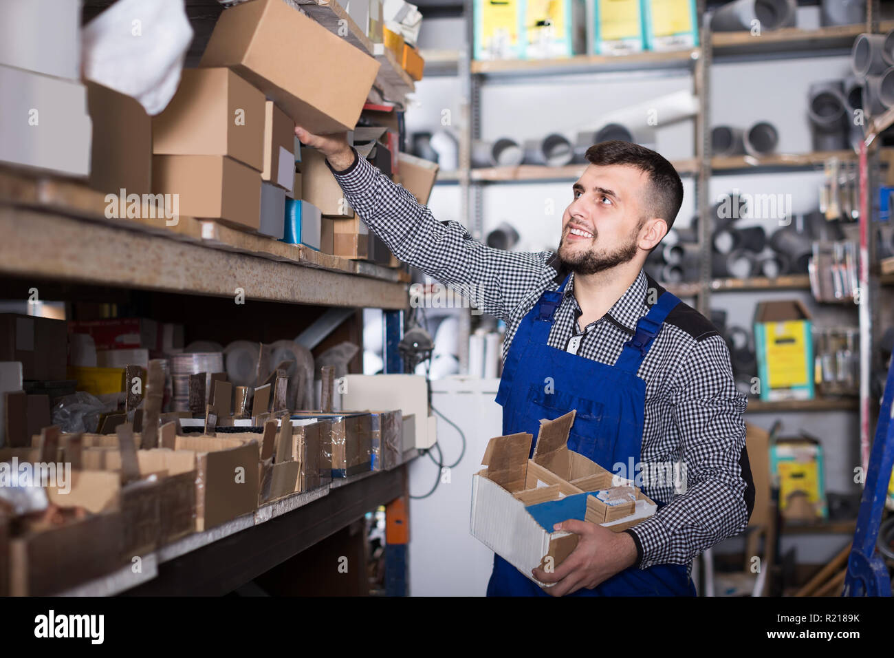 Uomo adulto lavoratore ordinamento ingegneria sanitaria dettagli in officina Foto Stock