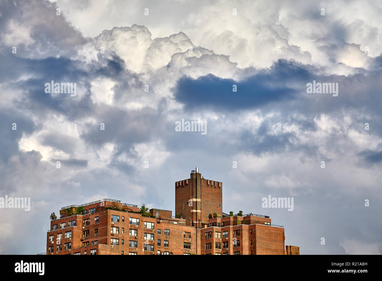 Drammatica cloudscape su un vecchio edificio residenziale nella città di New York, Stati Uniti d'America. Foto Stock