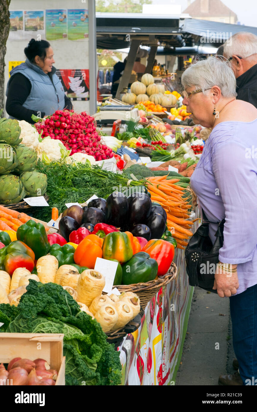 St-Cyprien, Dordogne, Francia - 24 Settembre 2015: Shoppers esaminare i coloratissimi banchi di frutta e verdura visualizzato durante la Domenica street market in St-Cyprien, Dordogne, Francia Foto Stock