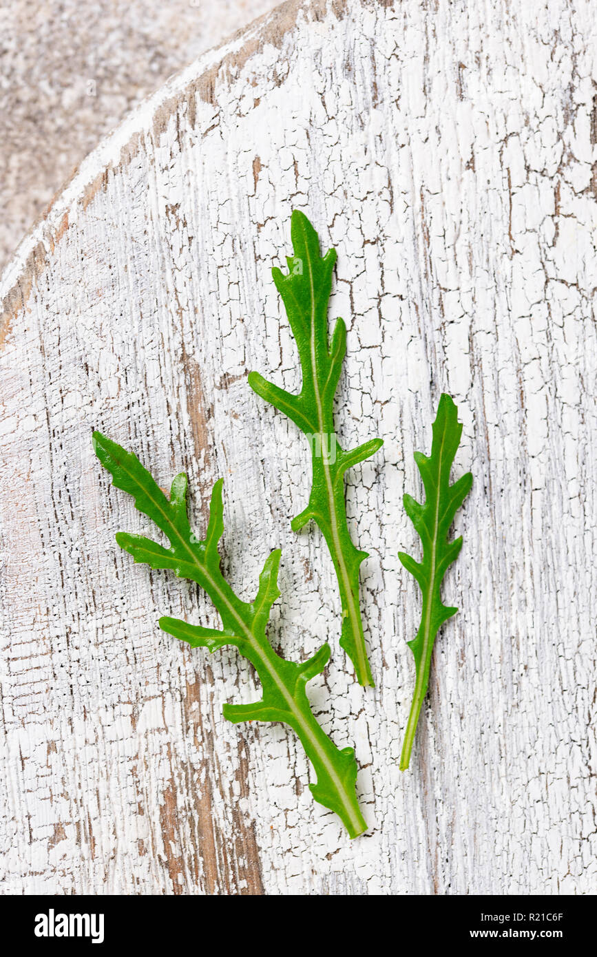 Fresche foglie di rucola sul tavolo luminoso Foto Stock