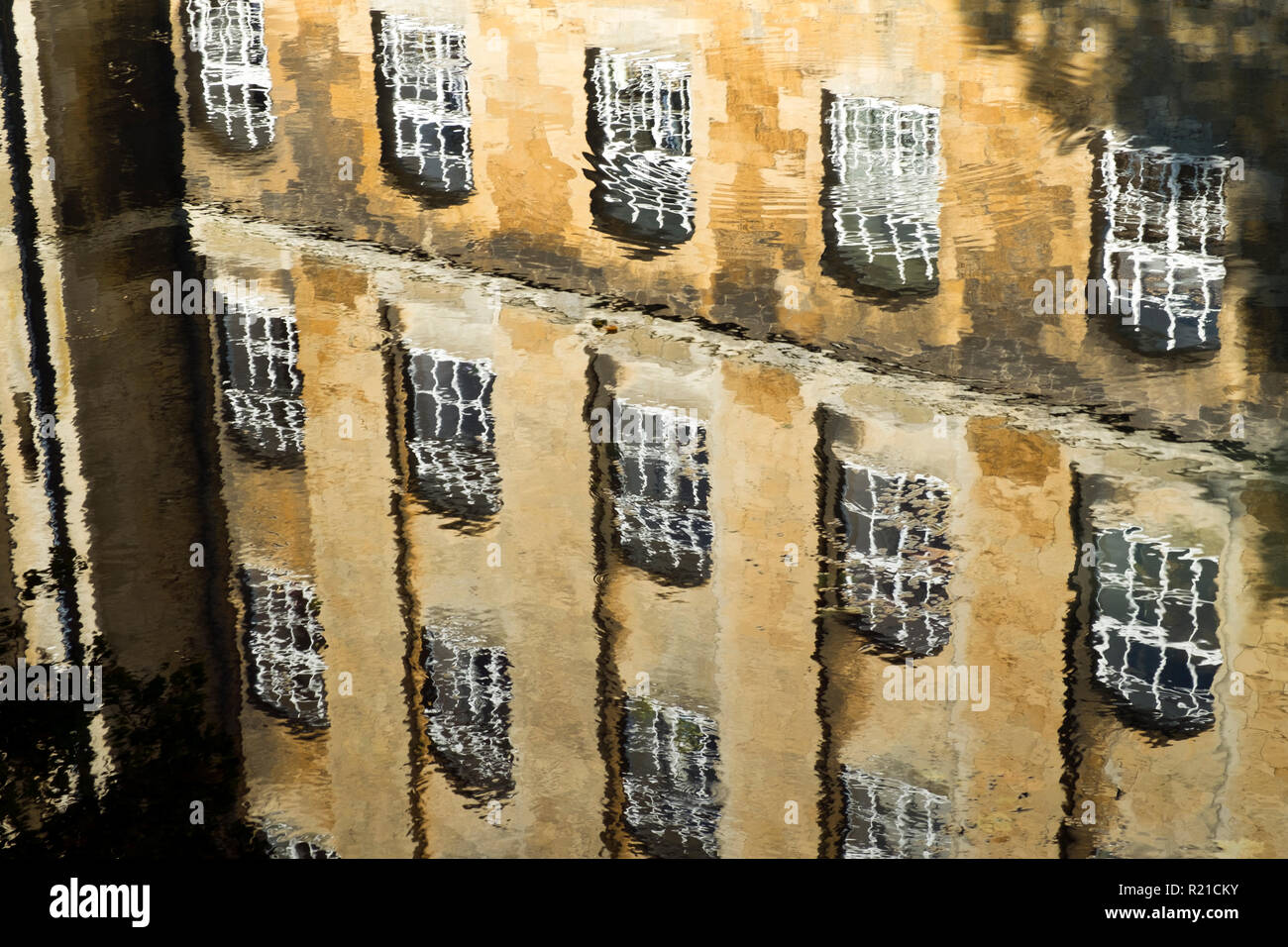 Architettura Industriale riflessioni nel fiume Avon in autunno sunshine, Bradford on Avon, Wiltshire, Regno Unito Foto Stock