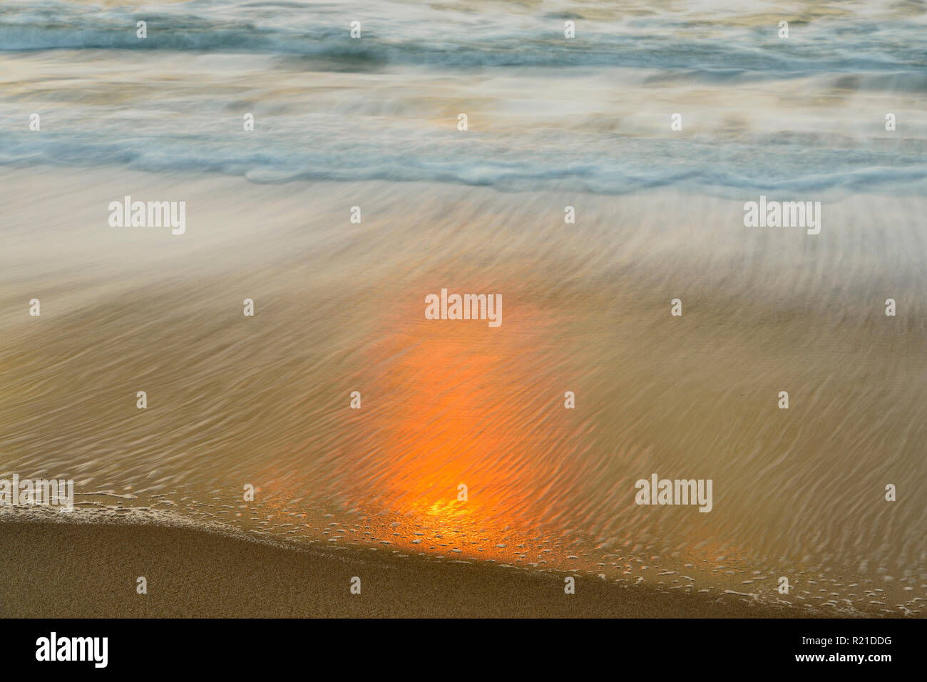 Il surf e la luce del sole riflessa sul bagnato di sabbia sulla spiaggia al tramonto , Ventura , California, USA Foto Stock