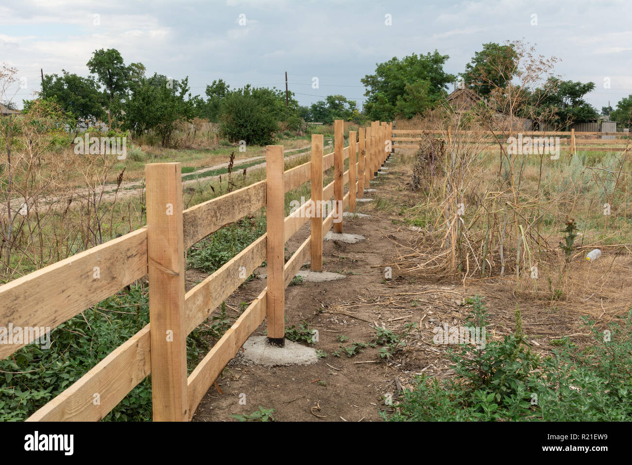 Stile Ranch recinto. Rurale di recinzione in legno su erba verde al ranch farm land in Shagany, Ukraina. Foto Stock