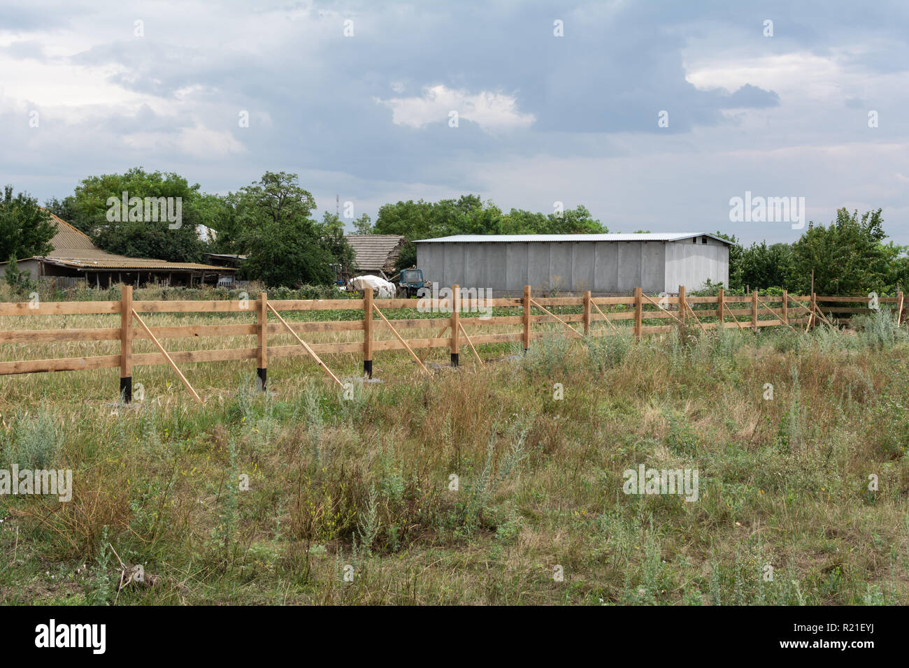 Stile Ranch recinto. Rurale di recinzione in legno su erba verde al ranch farm land in Shagany, Ukraina. Foto Stock