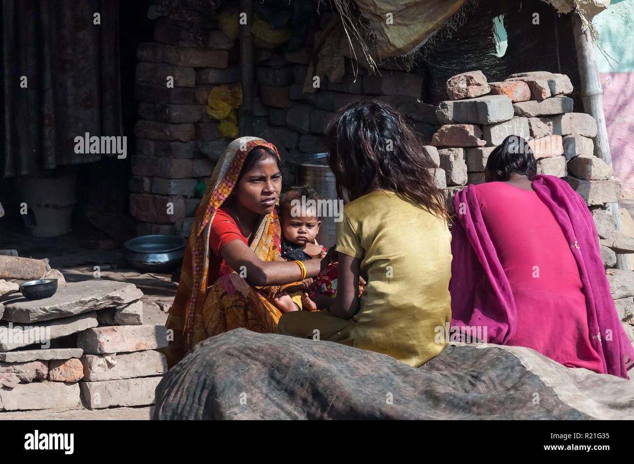 India persone nella vita di tutti i giorni. Una donna con un bambino sta parlando con le sue figlie più anziane India Agra 2012 Foto Stock