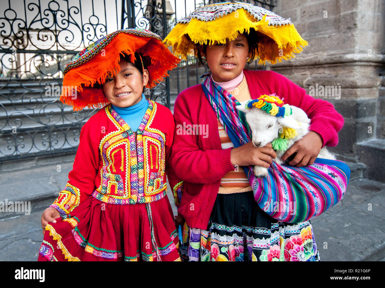 Perù e Bolivia persone nella vita quotidiana. 2013. Due bambine in abiti tradizionali peruviani e un agnello in braccio. Foto Stock
